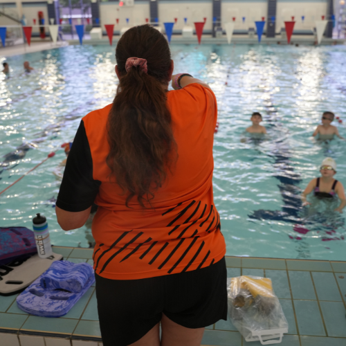 Swimming lesson happening in a pool with an instructor